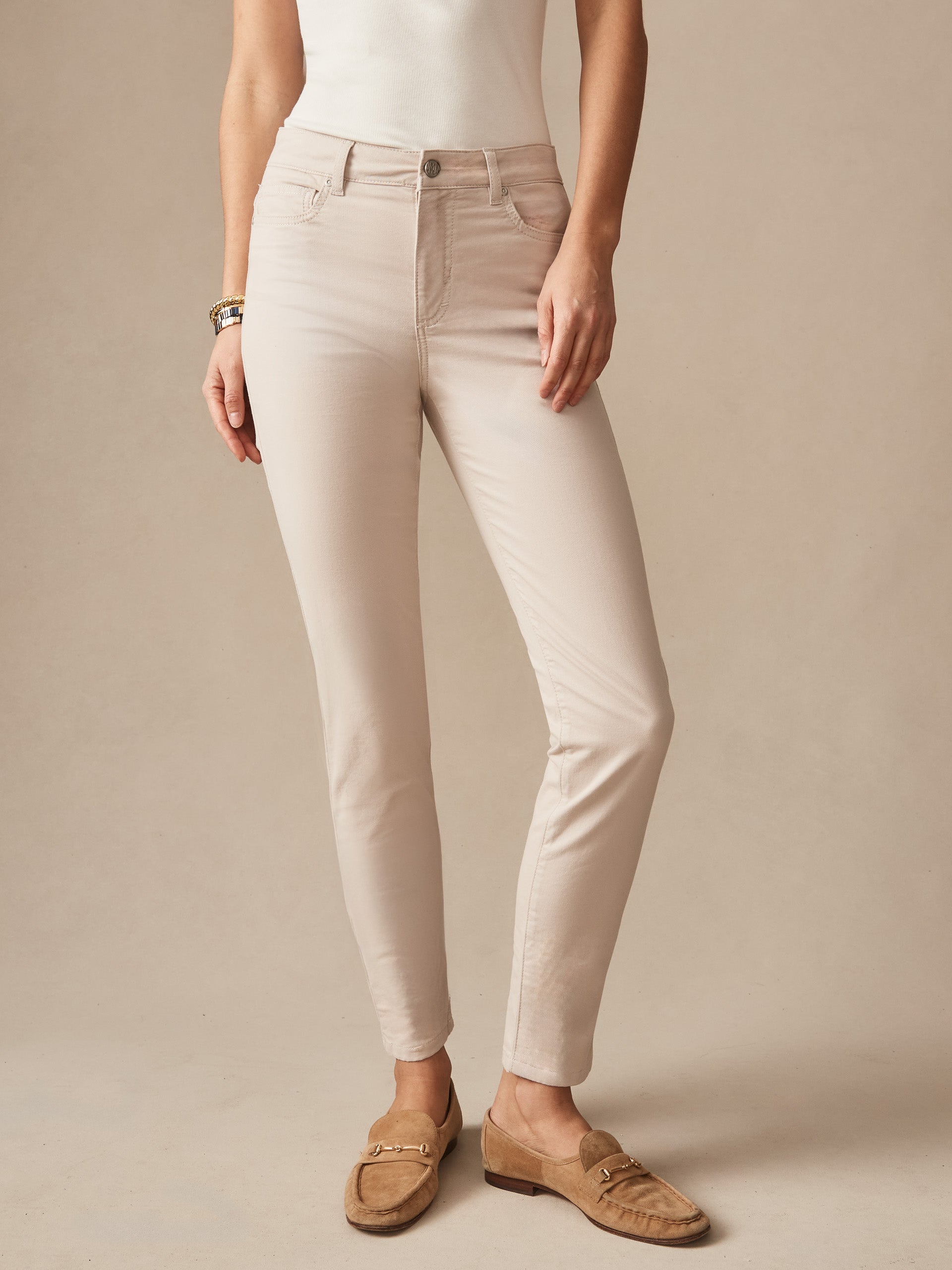 Woman wearing Watson Cotton Cashmere Pants in a soft stone color, paired with a white top and suede loafers, showcasing J.McLaughlin's effortlessly stylish, enduring designs.