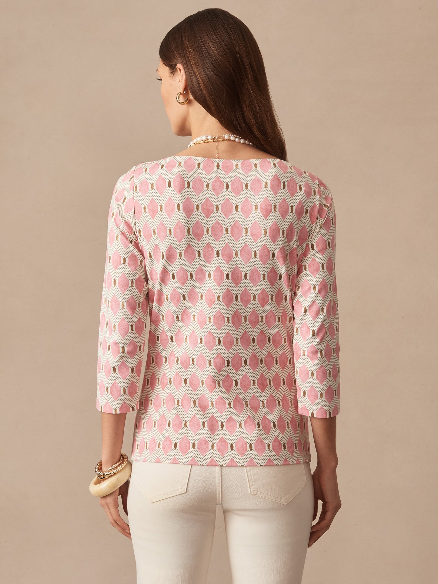 A woman models the Wavesong Tee in Mini Beekeeper by J.McLaughlin, featuring an effortlessly stylish pink and tan patterned top with three-quarter sleeves, blending enduring designs and innovative fabrics for a legacy of timeless fashion. A destination for defining style. Life, Well-Lived.