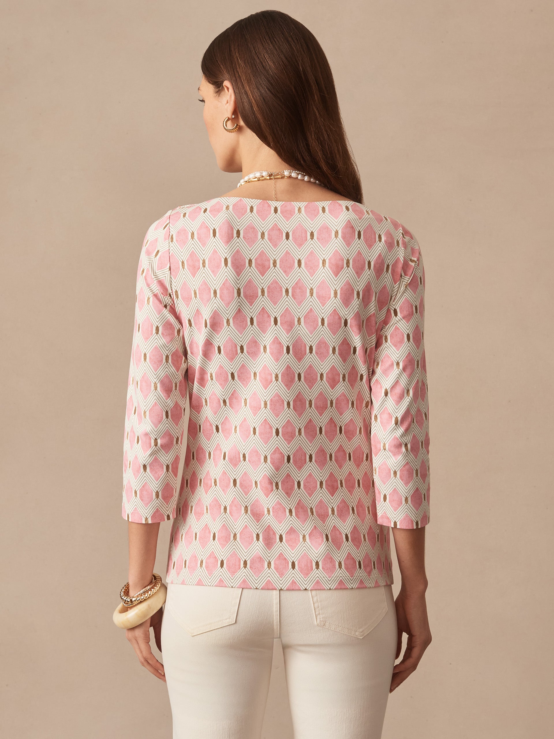 A woman models the Wavesong Tee in Mini Beekeeper by J.McLaughlin, featuring an effortlessly stylish pink and tan patterned top with three-quarter sleeves, blending enduring designs and innovative fabrics for a legacy of timeless fashion. A destination for defining style. Life, Well-Lived.