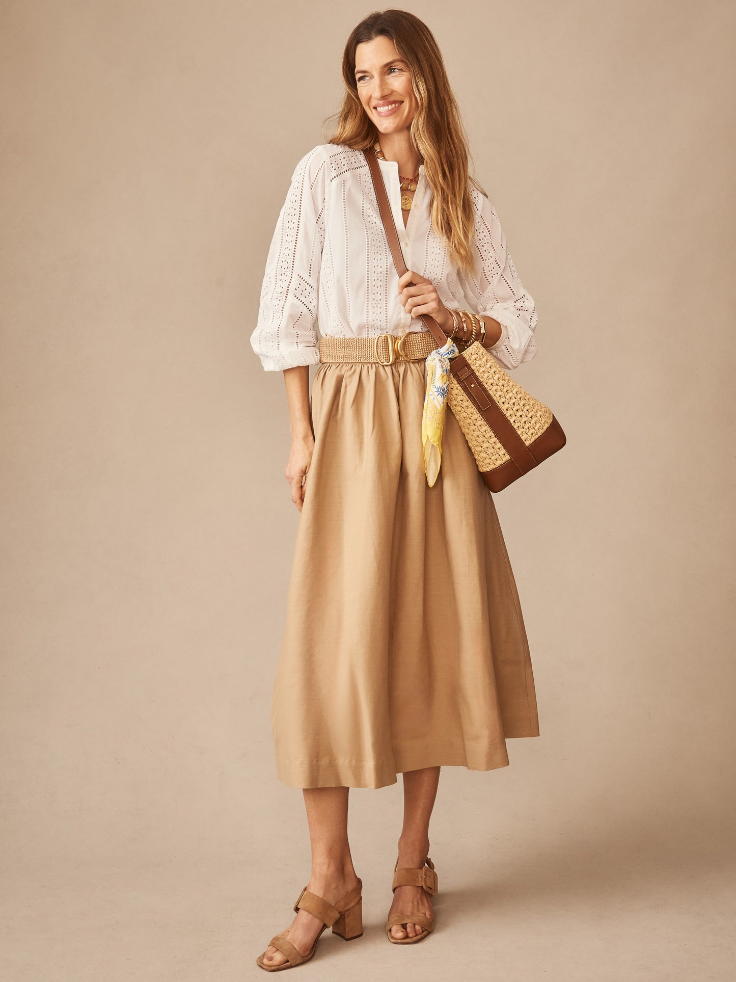 Woman wearing a white eyelet blouse paired with the Winnie Linen Blend Skirt in a soft khaki tone by J.McLaughlin, showcasing effortlessly stylish, enduring designs and innovative fabrics.