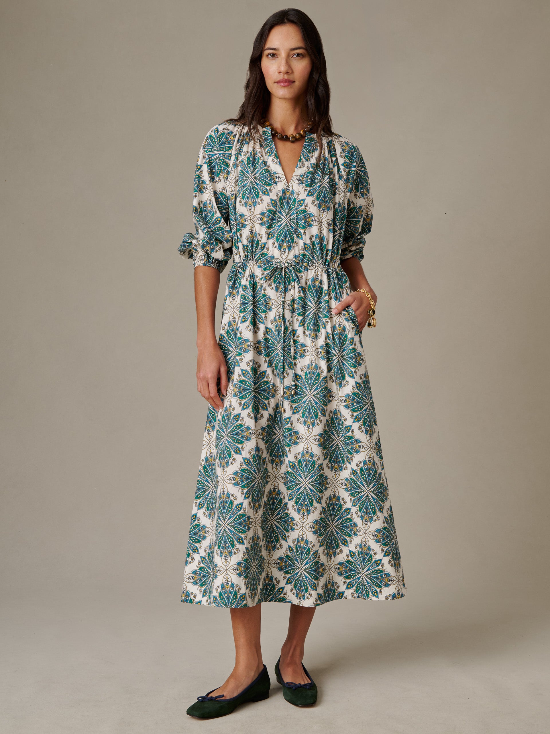 Woman wearing the Winslet Dress in Neo Radiant by J.McLaughlin, featuring a stylish patterned midi length design with puffed sleeves, embodying effortlessly stylish, enduring designs.