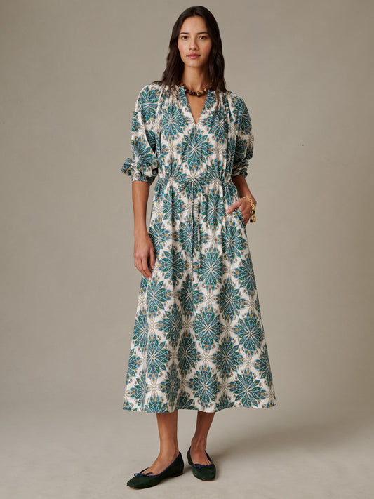 Woman wearing the Winslet Dress in Neo Radiant by J.McLaughlin, featuring a stylish patterned midi length design with puffed sleeves, embodying effortlessly stylish, enduring designs.